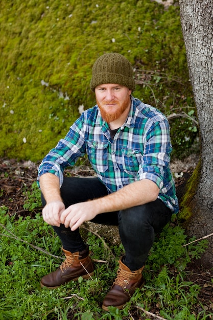 Foto portret van een hipster man denken in het bos