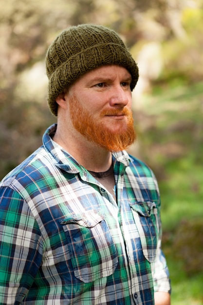 Foto portret van een hipster man denken in het bos