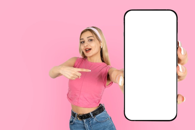 Portret van een jong blond meisje met een leeg scherm smartphone mobiele telefoon mock up
