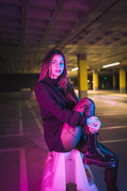 Portret van een jong brunette Kaukasisch model 's nachts op een ondergrondse parkeerplaats