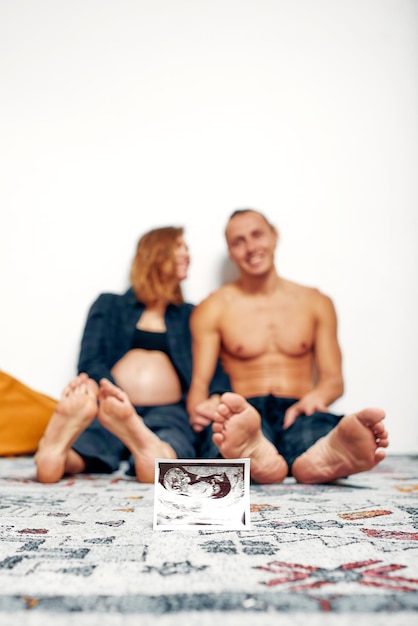 Portret van een jong gelukkig getrouwd stel met echografiefoto Vrolijke familie en echografiefoto Concept van zwangerschap gezondheidszorg gynaecologie Moeder wachtende baby