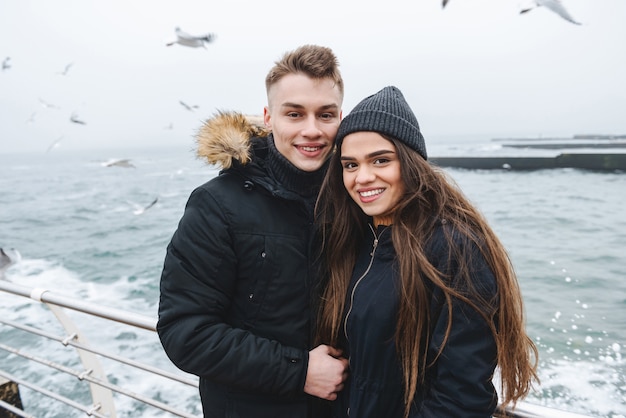 portret van een jong gelukkig liefdevol paar wandelen op het strand buitenshuis.