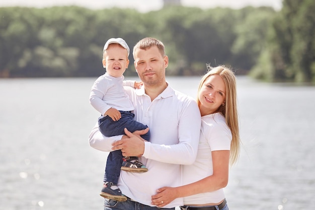 Portret van een jong gezin op de achtergrond van een meer