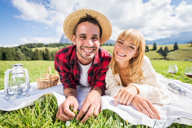 Portret van een jong koppel in liefde die picknick doet die de dolomieten van de alpen bezoeken