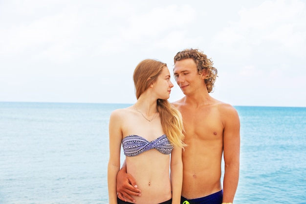 Portret van een jong koppel in liefde op het strand en genieten van tijd samenzijn. Jong koppel plezier op een zandige kust.