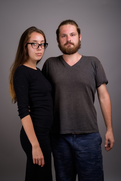 Portret van een jong koppel samen tegen een grijze achtergrond