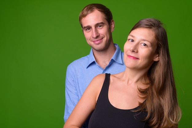 Portret van een jong koppel samen tegen groene muur