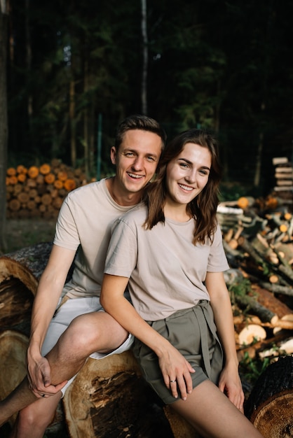 Foto portret van een jong koppel verliefd op gekapte bomen in het bos.