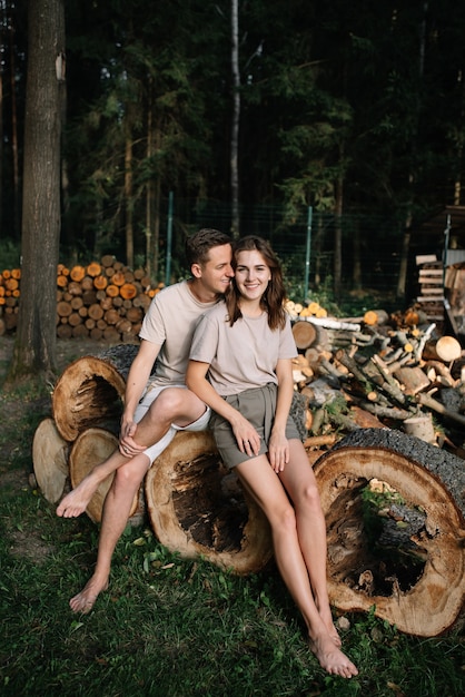 Foto portret van een jong koppel verliefd op gekapte bomen in het bos.