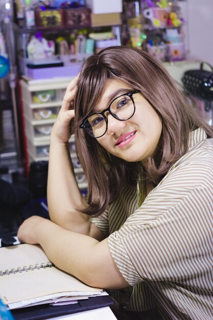 Portret van een jong meisje dat aan een bureau zit met een open boek