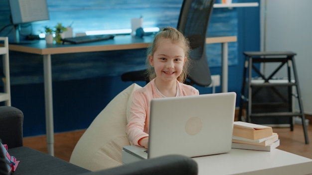 Portret van een jong meisje dat aan laptop werkt voor schoollessen