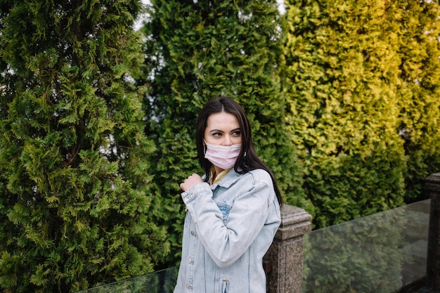 Portret van een jong meisje dat een masker draagt in het stadsstraatconcept van vervuiling
