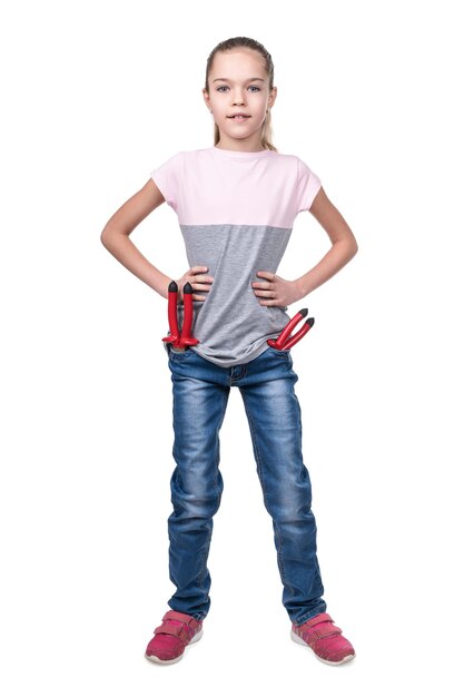 Portret van een jong meisje in jeans met gereedschap in zakken geïsoleerd op een witte achtergrond