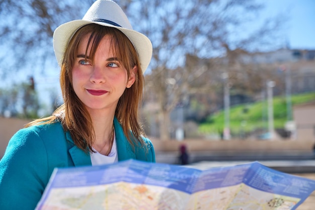 Portret van een jong meisje met blauwe ogen van stadstoerisme met een plattegrond in haar handen