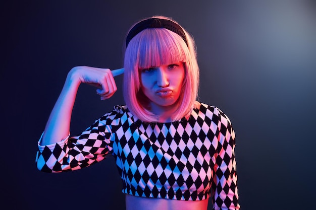 Portret van een jong meisje met blond haar in rood en blauw neon in studio