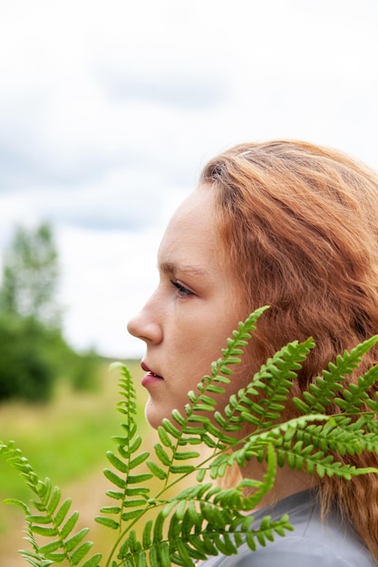 Portret van een jong meisje met groen varenblad