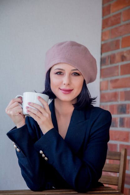 Portret van een jong meisje met kop koffie