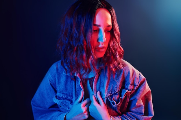 Portret van een jong meisje met krullend haar in rood en blauw neon in studio