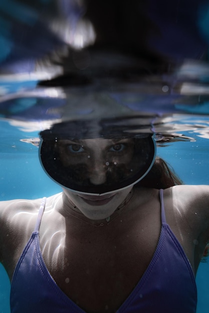 Foto portret van een jong meisje onder water met duikbril