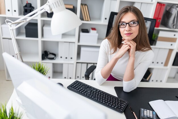 Portret van een jong meisje op een computer Bureau in het kantoor.