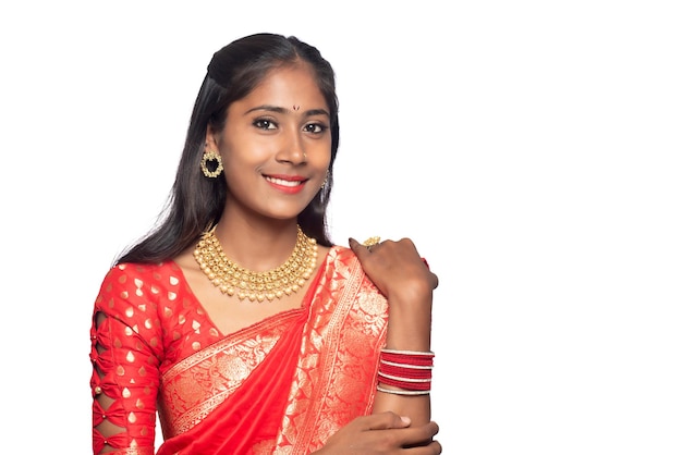 Portret van een jong meisje op Indiase traditionele sari die zich voordeed op een witte achtergrond