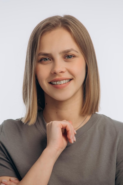Portret van een jong mooi meisje met bretels op een witte achtergrond