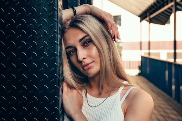 Foto portret van een jong mooi meisje op een stadsstraat in de zomer