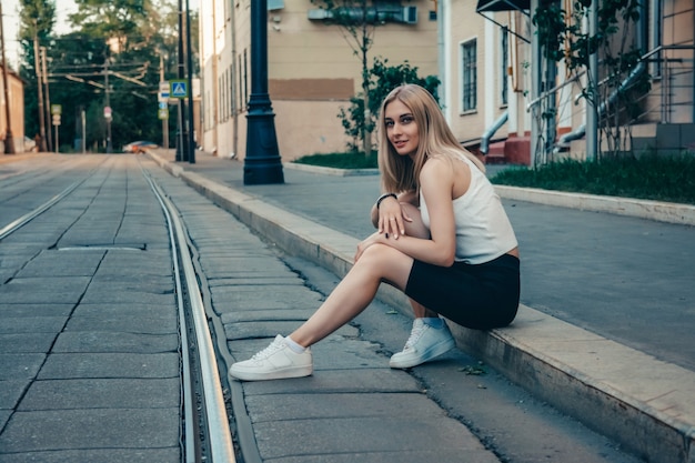 Foto portret van een jong mooi meisje op een stadsstraat in de zomer