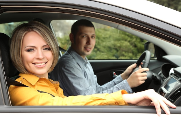 Portret van een jong mooi stel dat in de auto zit