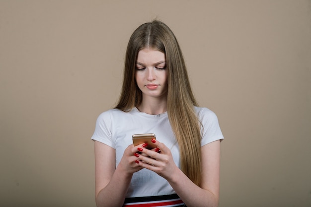 Portret van een jonge aantrekkelijke vrouw die een selfie-foto maakt op een smartphone die op een witte achtergrond wordt geïsoleerd