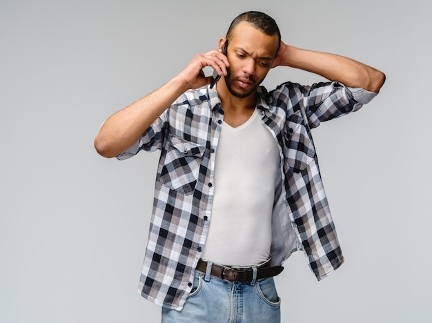 Portret van een jonge Afrikaanse Amerikaanse mens die mobiele celtelefoon houdt.