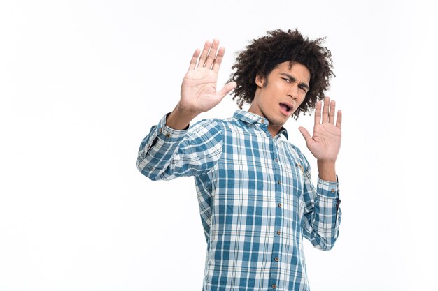 Portret van een jonge Afro-Amerikaanse man met walging emotie staande geïsoleerd op een witte muur