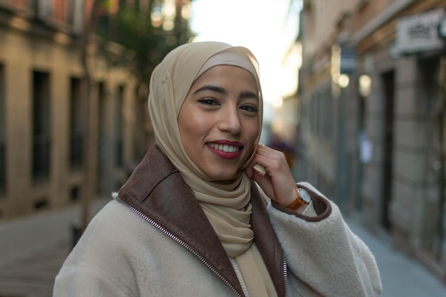 Portret van een jonge Arabische mooie vrouw in traditionele hoofddoek die vrolijk naar de camera glimlacht