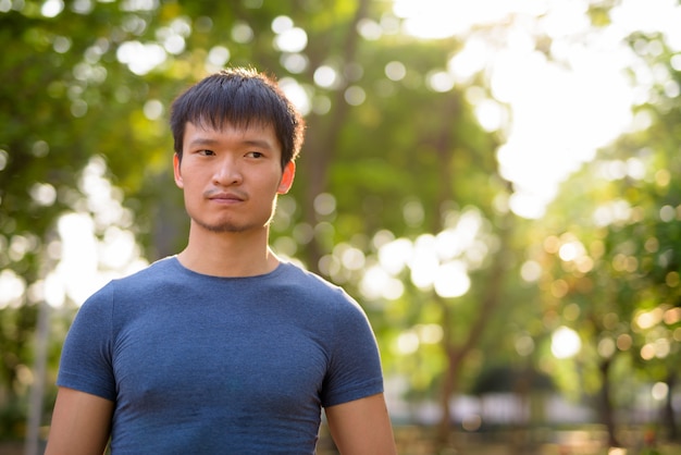 Foto portret van een jonge aziatische man in het park buiten