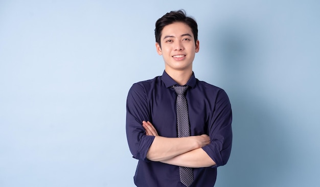 Portret van een jonge Aziatische zakenman die zich voordeed op een blauwe achtergrond