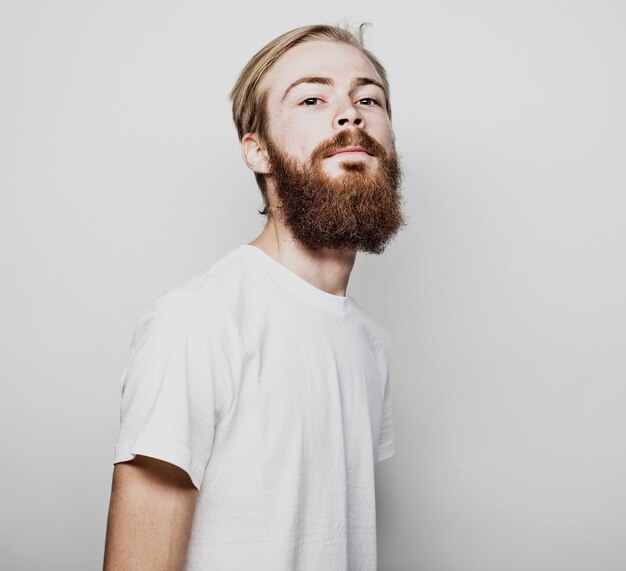 Portret van een jonge, bebaarde man in een wit T-shirt