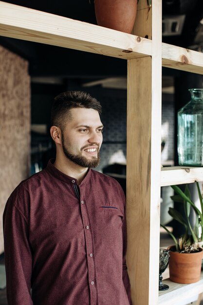 Portret van een jonge, bebaarde man voor de deur