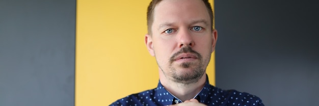 Portret van een jonge biddende man in een shirt, de man met de borstelharen zit in een bedachtzame pose