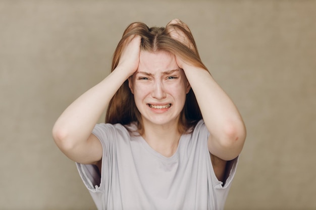 Portret van een jonge blanke actrice huilende boos vrouw tegen een beige achtergrond Acteertest Casting film film acteeraudities