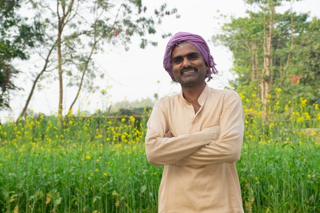 Portret van een jonge boer die bij een boerderij staat