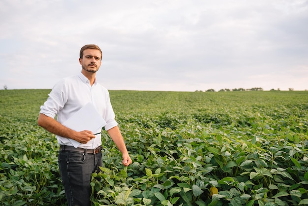 Portret van een jonge boer die in een veld van sojabonen staat.