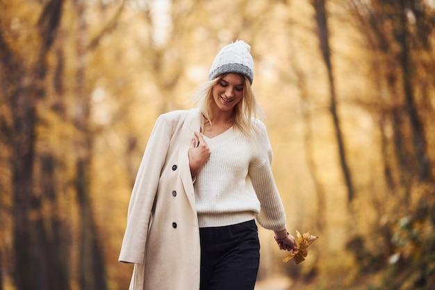 Portret van een jonge brunette die overdag een wandeling maakt in het herfstbos.