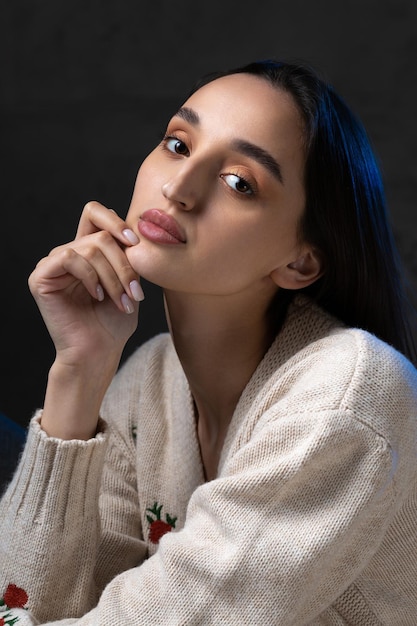 Portret van een jonge brunette met lang haar in de studio Dramatische foto in donkere kleuren