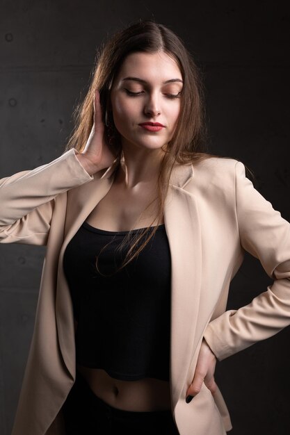 Portret van een jonge brunette met lang haar in de studio Dramatische foto in donkere kleuren