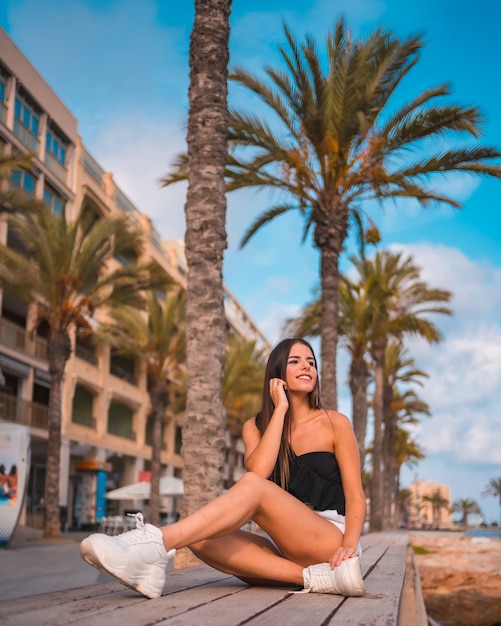 Portret van een jonge brunette vrouw die geniet van haar dag aan de kust aan het strand