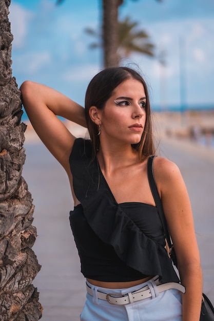 Portret van een jonge brunette vrouw die geniet van haar dag aan de kust aan het strand