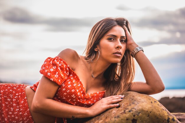 Portret van een jonge brunette vrouw in een rode jurk