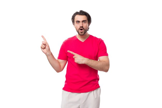 Portret van een jonge brute man gekleed in een rood T-shirt met een mock-up voor het afdrukken