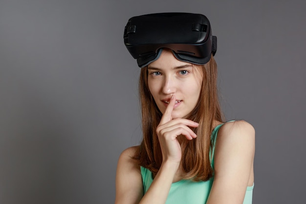 Portret van een jonge dame die een VR-bril draagt en naar de camera kijkt