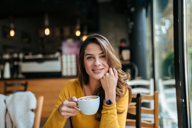 Portret van een jonge dame koffie drinken.